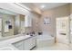 Well-lit bathroom with a soaking tub, tile flooring and dual sinks at 951 Sea Fox Rd, Venice, FL 34293