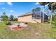 Back exterior of home with fire pit area and enclosed patio at 951 Sea Fox Rd, Venice, FL 34293