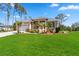 Charming tan home featuring a spacious two-car garage, manicured lawn, and beautifully landscaped front yard at 951 Sea Fox Rd, Venice, FL 34293