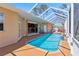 The enclosed pool features a tiled deck and glass enclosure with patio access to the kitchen and seating at 951 Sea Fox Rd, Venice, FL 34293