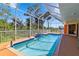 Enclosed pool features a tiled deck, staircase water feature, and covered, screened enclosure at 951 Sea Fox Rd, Venice, FL 34293
