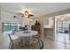 Open-concept dining room with modern decor, a ceiling fan, and a view of the living room and waterfront balcony at 990 Bird Bay Way # 258, Venice, FL 34285