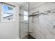 Walk-in shower featuring custom tile work and a glass enclosure at 990 Bird Bay Way # 258, Venice, FL 34285