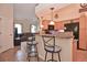 Open kitchen featuring a breakfast bar with stools, granite countertops, and modern appliances at 1000 Gardens Edge Dr # 1023, Venice, FL 34285