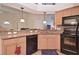 Functional kitchen with granite countertops, modern appliances, and a view into the living area at 1000 Gardens Edge Dr # 1023, Venice, FL 34285