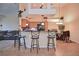 Stylish kitchen with bar seating, granite countertops, and modern lighting fixtures, open to dining area at 1000 Gardens Edge Dr # 1023, Venice, FL 34285