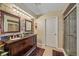 Bathroom featuring double sinks with stone accent wall, granite countertop, and glass door shower at 1003 N Gondola Dr, Venice, FL 34293