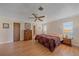 Bedroom featuring natural light, warm wood floors, ceiling fan, and ensuite bathroom at 1003 N Gondola Dr, Venice, FL 34293