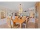 Elegant dining room features a stylish chandelier, adjacent living spaces, and tile flooring at 1003 N Gondola Dr, Venice, FL 34293