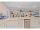 Kitchen with white cabinetry, stainless steel appliances, and a view into the living spaces at 1003 N Gondola Dr, Venice, FL 34293