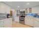 Well-equipped kitchen features modern appliances, white cabinets, and tile backsplash at 1003 N Gondola Dr, Venice, FL 34293