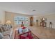 Cozy living room with tile flooring, a large bay window, comfortable sofa, and tasteful decor, creating a welcoming atmosphere at 1003 N Gondola Dr, Venice, FL 34293