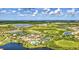 Wide aerial view of Sarasota National with a focus on the lake, golf course, community amenities and surrounding landscape at 10064 Cozy Grove Dr, Venice, FL 34293