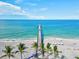 Scenic view of a wooden pier extending into turquoise water with palm trees at 10064 Cozy Grove Dr, Venice, FL 34293
