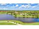 Stunning aerial view of a golf course community, lake, and golf carts at 10064 Cozy Grove Dr, Venice, FL 34293