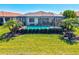 A screened-in pool with lush tropical landscaping and well manicured green lawn at 10064 Cozy Grove Dr, Venice, FL 34293