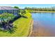 A screened-in pool with water view in the backyard and lush tropical landscaping at 10064 Cozy Grove Dr, Venice, FL 34293
