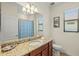 Well-lit bathroom with a granite countertop, vanity, and a shower with a patterned curtain at 10064 Cozy Grove Dr, Venice, FL 34293