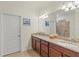 Elegant bathroom with dual sinks, granite countertops, and a stylishly tiled shower area at 10064 Cozy Grove Dr, Venice, FL 34293