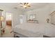 Bright bedroom featuring neutral tones, a ceiling fan and en-suite bathroom access at 10064 Cozy Grove Dr, Venice, FL 34293