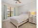 Cozy bedroom with large window, dresser and ceiling fan at 10064 Cozy Grove Dr, Venice, FL 34293