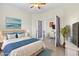 Bedroom with blue accents, tile floors, adjacent room and fan at 10064 Cozy Grove Dr, Venice, FL 34293
