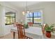 Bright dining room featuring a chandelier and scenic lake views through large windows at 10064 Cozy Grove Dr, Venice, FL 34293