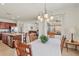 Inviting dining area with chandelier, seamlessly connected to the open-concept kitchen and living spaces at 10064 Cozy Grove Dr, Venice, FL 34293