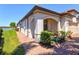 Exterior view with an arched portico, manicured landscaping, and a brick walkway leading to the entrance at 10064 Cozy Grove Dr, Venice, FL 34293