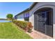 Charming home exterior with a secure screen door and neat landscaping along the brick walkway at 10064 Cozy Grove Dr, Venice, FL 34293