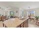 Granite kitchen island with sink, stainless steel appliances, and open views to the living area at 10064 Cozy Grove Dr, Venice, FL 34293