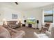 Relaxing living room with comfortable furniture, large TV, and natural light from the window at 10064 Cozy Grove Dr, Venice, FL 34293