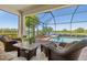 Screened-in patio area with comfortable seating overlooking the pool and water view at 10064 Cozy Grove Dr, Venice, FL 34293