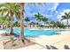 Large community swimming pool surrounded by mature palm trees, lounge chairs, and pristine landscaping at 10064 Cozy Grove Dr, Venice, FL 34293