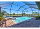 Backyard screened pool with spa tub and brick pavers, perfect for relaxation at 10064 Cozy Grove Dr, Venice, FL 34293