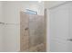 Modern tiled walk-in shower featuring glass door and tiled accent window at 10064 Cozy Grove Dr, Venice, FL 34293