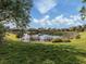 Backyard view of a scenic pond and mature landscaping at 101 Portofino Dr, North Venice, FL 34275