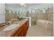 Primary bathroom features a glass shower, soaking tub, and decorative gothic-style windows at 101 Portofino Dr, North Venice, FL 34275