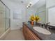 Bathroom with double sinks, granite countertop, shower, and tile floors at 101 Portofino Dr, North Venice, FL 34275