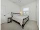 Bedroom with neutral carpet, window, and a dark wood bed frame at 101 Portofino Dr, North Venice, FL 34275