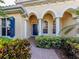 Inviting front entrance with brick pathway, arched entryway, and lush landscaping at 101 Portofino Dr, North Venice, FL 34275