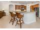 Bright kitchen featuring granite countertops, wood cabinetry, and bar stool seating at 101 Portofino Dr, North Venice, FL 34275