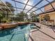 Screened in pool with spa and outdoor kitchen featuring a stainless steel grill and outdoor kitchen at 101 Portofino Dr, North Venice, FL 34275
