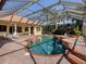 Screened in pool with spa and outdoor kitchen with ample seating and stainless steel BBQ at 101 Portofino Dr, North Venice, FL 34275