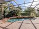 Screened in pool area with waterfall feature, mature landscaping and lounge area at 101 Portofino Dr, North Venice, FL 34275