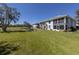 Backyard view of the building features well-maintained lawn and a pond at 1041 Capri Isles Blvd # 224, Venice, FL 34292