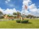 Charming clubhouse featuring manicured landscaping and an American flag flying high on a sunny day at 1041 Capri Isles Blvd # 224, Venice, FL 34292