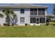 Back exterior of home with screened in lanai, sliding doors, and mature landscaping at 1041 Capri Isles Blvd # 224, Venice, FL 34292