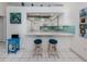Bright kitchen features white cabinets, breakfast bar with seating, and stylish light-blue backsplash at 1041 Capri Isles Blvd # 224, Venice, FL 34292