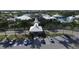 Community clubhouse aerial view featuring a covered entrance, lush landscaping, and parking at 109 Southampton N Pl # 245, Venice, FL 34293